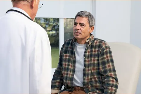 Actor portrayals of a man in a doctor's office, having a discussion with his doctor